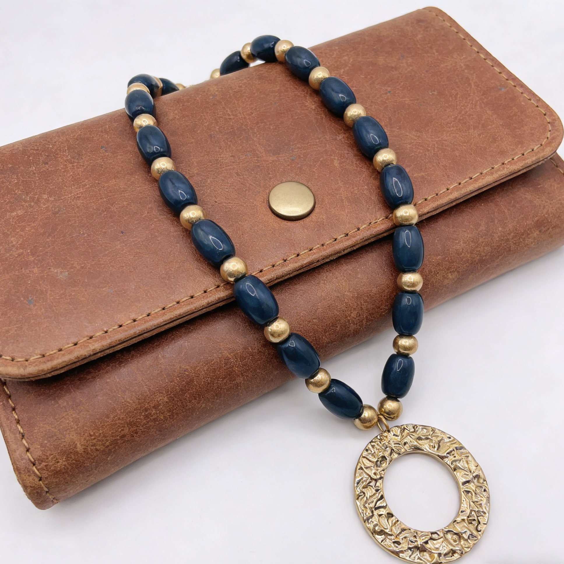 Conjunto de joias vintage com contas (3 cores): brincos compridos e colar com pendente circular.
